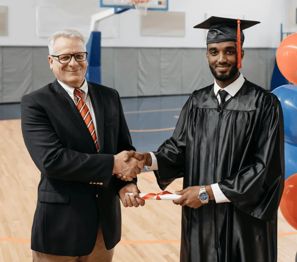 A smiling eLearning Department Director in academic regalia, representing a senior leadership role in higher education.