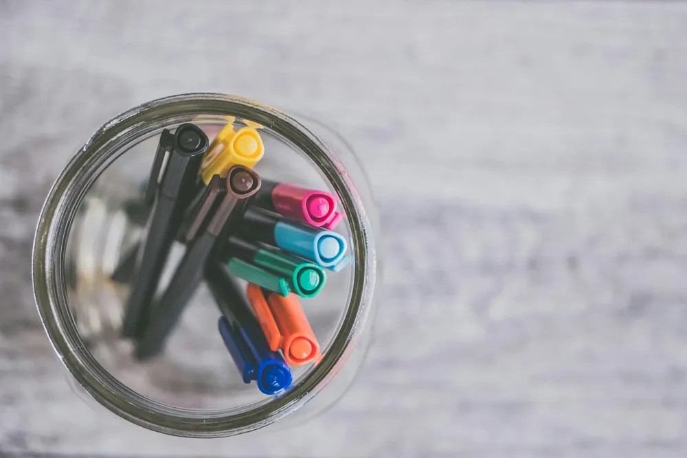 A close-up shot of a cup holding many different colored markers, symbolizing the variety of unique ID niches and specializations a professional can choose from.